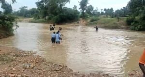 बाढ़ के बीच जान जोखिम में डालते हैं स्कूली बच्चे नदी पर पूर्ण होने से कई गांव के लोग परेशान देखिए कैसे पानी के मध्य स्कूल जाने को विवश है बच्चे 1 Screenshot 20250717 150136 Gallery 1